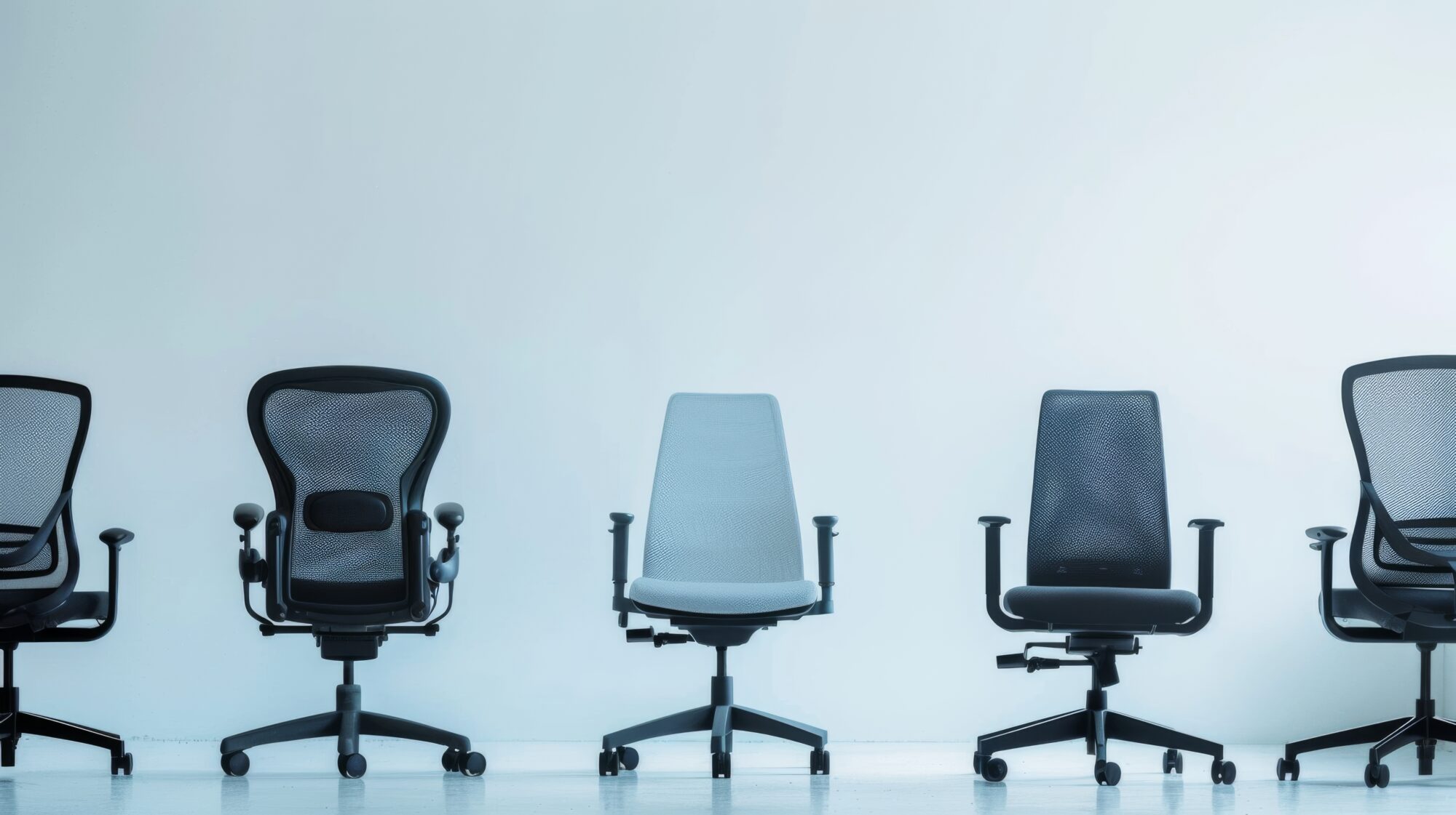 a row of various office chairs against a light blue wall, showcasing different designs and ergonomics.